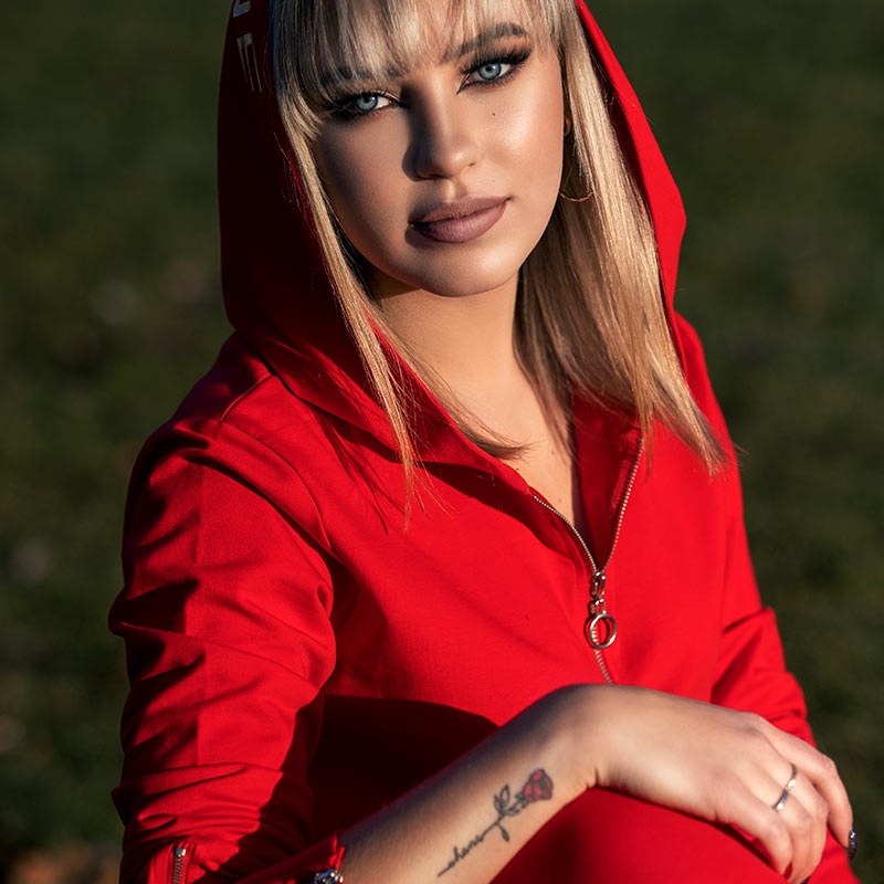 portret niebieskookiej blondynki w czerwonym dresie